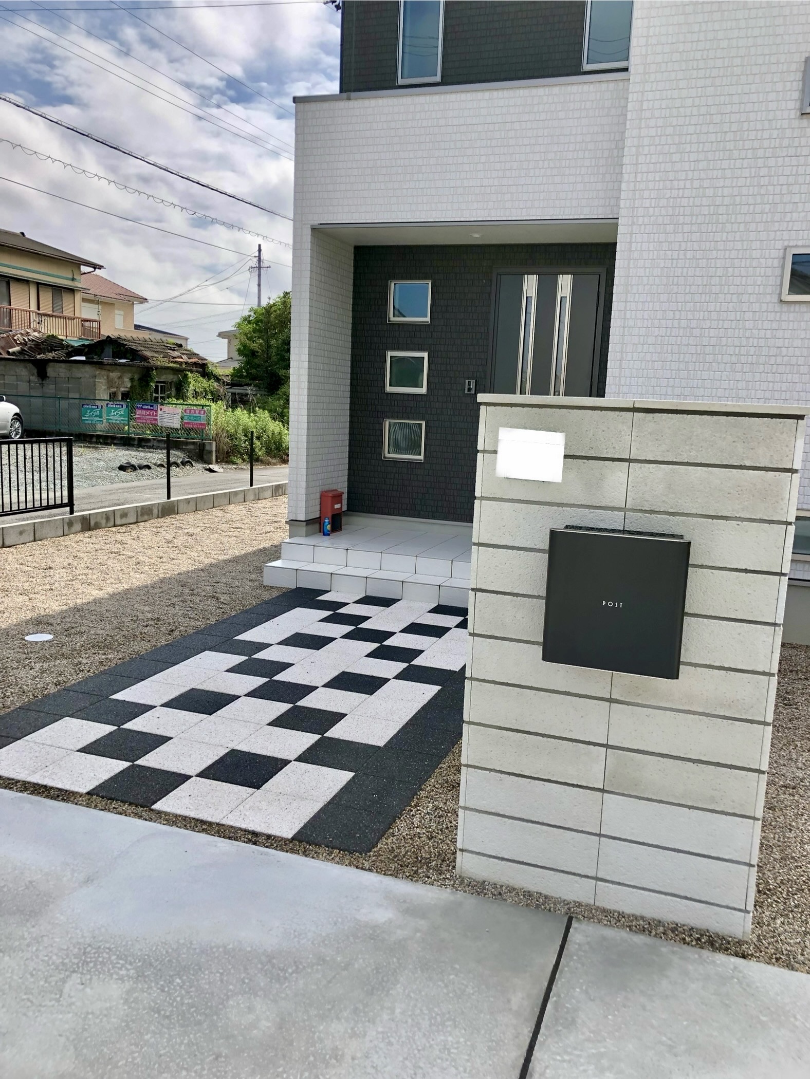 白と黒のインターロッキングが映える、モダンで印象的なアプローチ